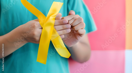 Cropped view of couple holding yellow ribbon on colorful background international childhood cancer day concept : Generative AI photo