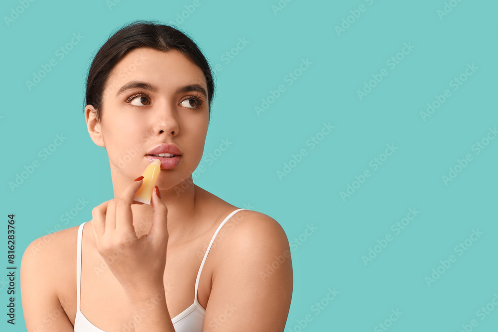 Young woman applying lip balm on color background Young woman applying lip balm on color background
