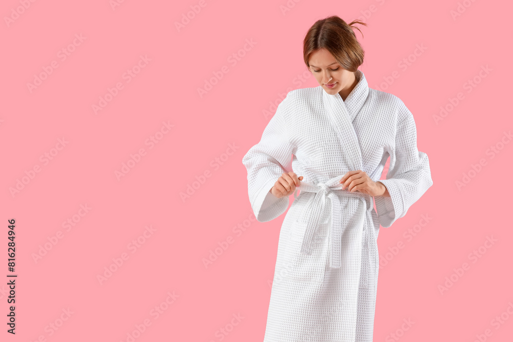 Beautiful young woman in bathrobe on pink background Beautiful young woman in bathrobe on pink background
