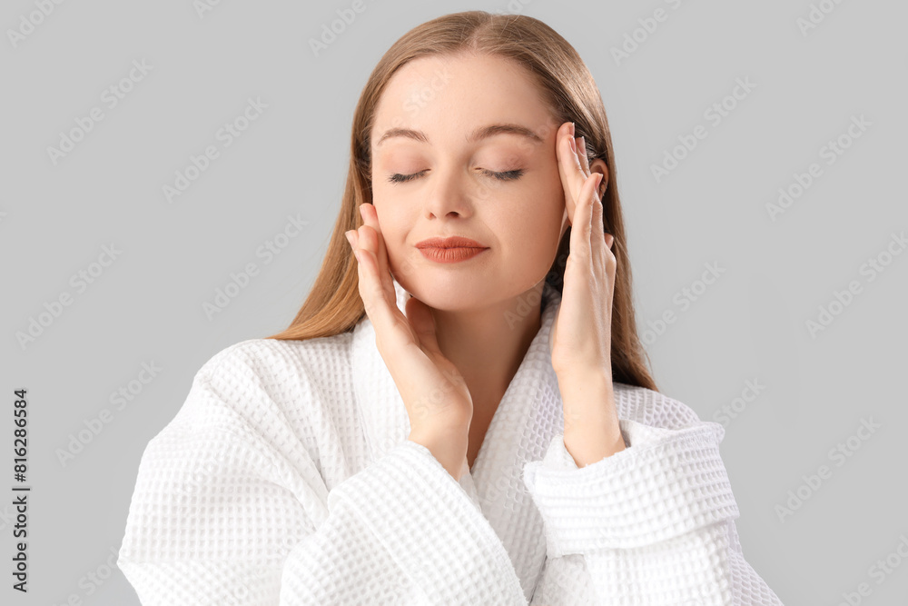 Young woman in bathrobe on light background, closeup Young woman in bathrobe on light background, closeup