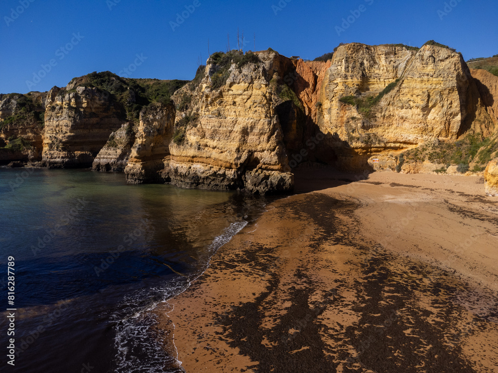 Obraz premium Praia de Dona Ana beach near Lagos town, Algarve, Portugal. Praia Dona Ana beach with turquoise sea water and cliffs, Portugal. Drone aerial view