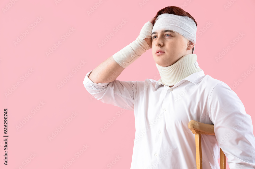 Injured young man after accident with crutch on pink background Injured young man after accident with crutch on pink background
