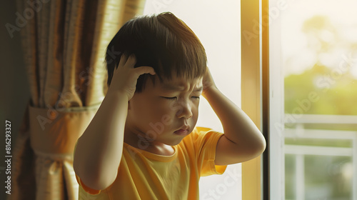 Little Asian boy stand by window cry and cover ears feeling fear insecure anxiety and stress Domestic Violence Autism disorder spectrum awareness and Childhood mental disorders problem : Generative AI photo