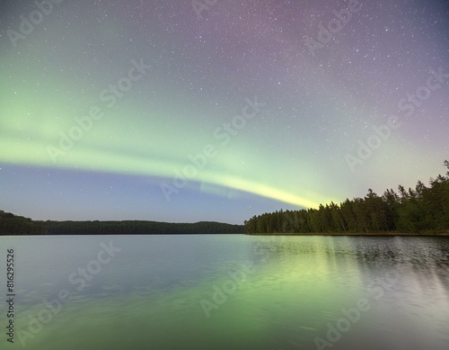 a beautiful aurora bore over a lake with a forest in the background.