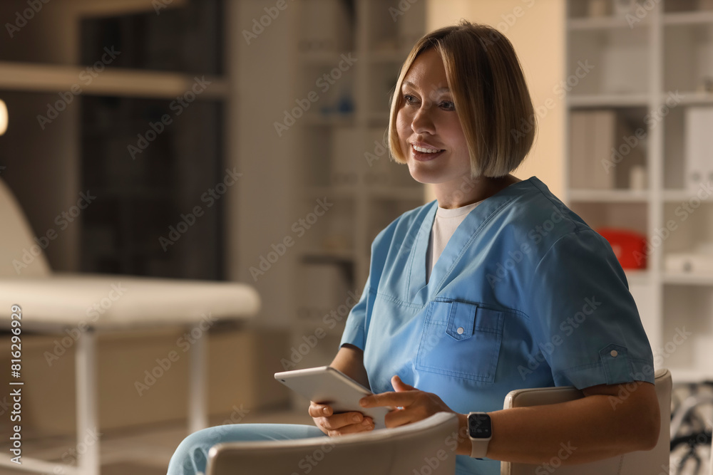 Female nurse with tablet computer working evening shift in clinic Female nurse with tablet computer working evening shift in clinic