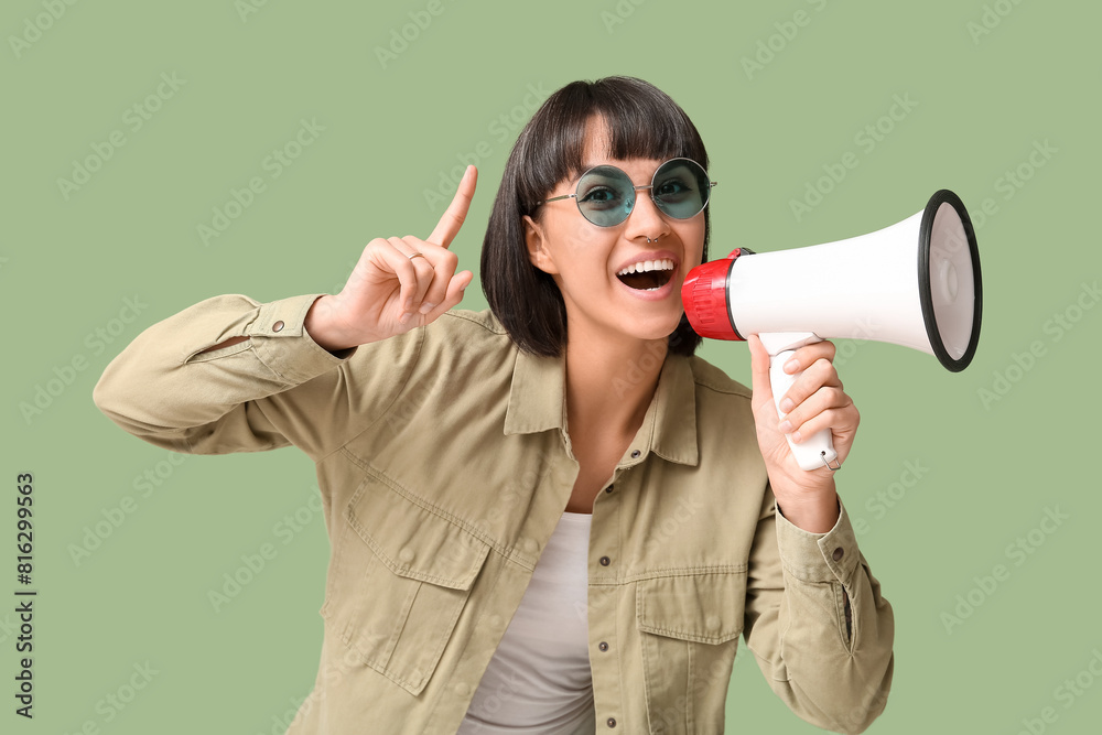 Naklejka premium Young woman with megaphone on green background