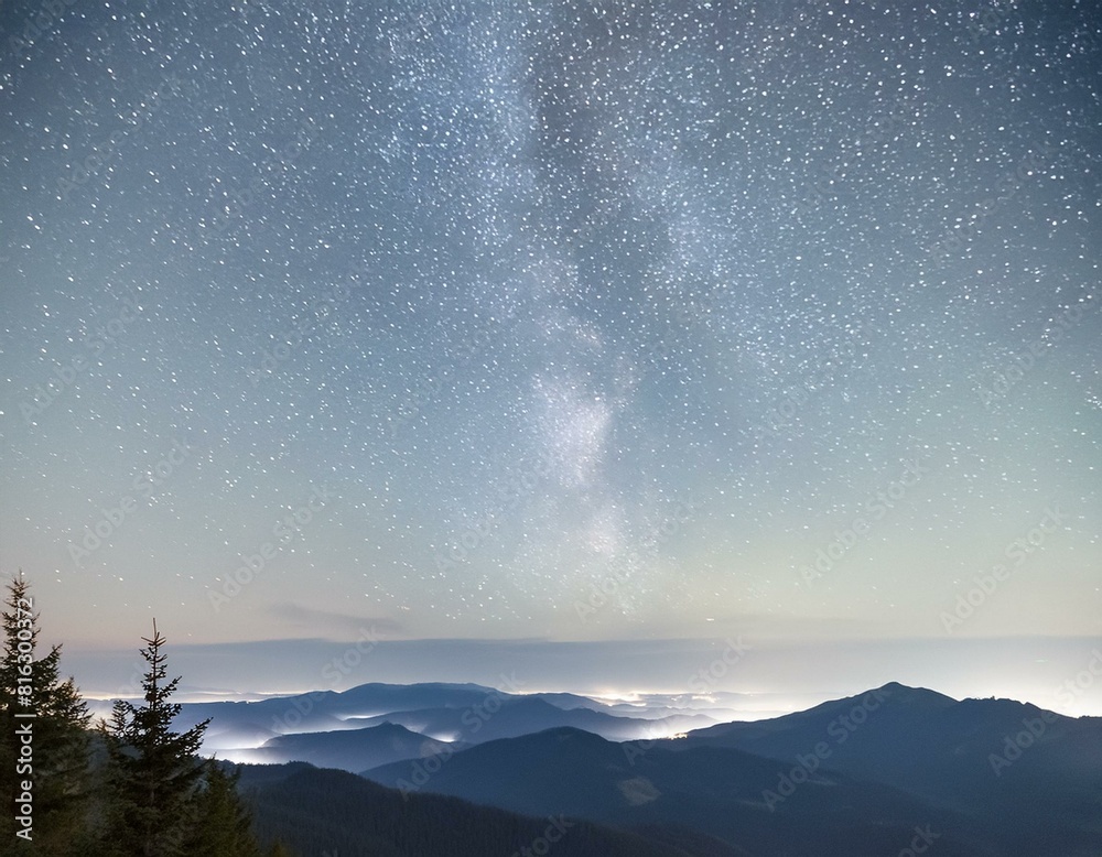 Fototapeta premium a night sky filled with stars and a mountain range in the distance.