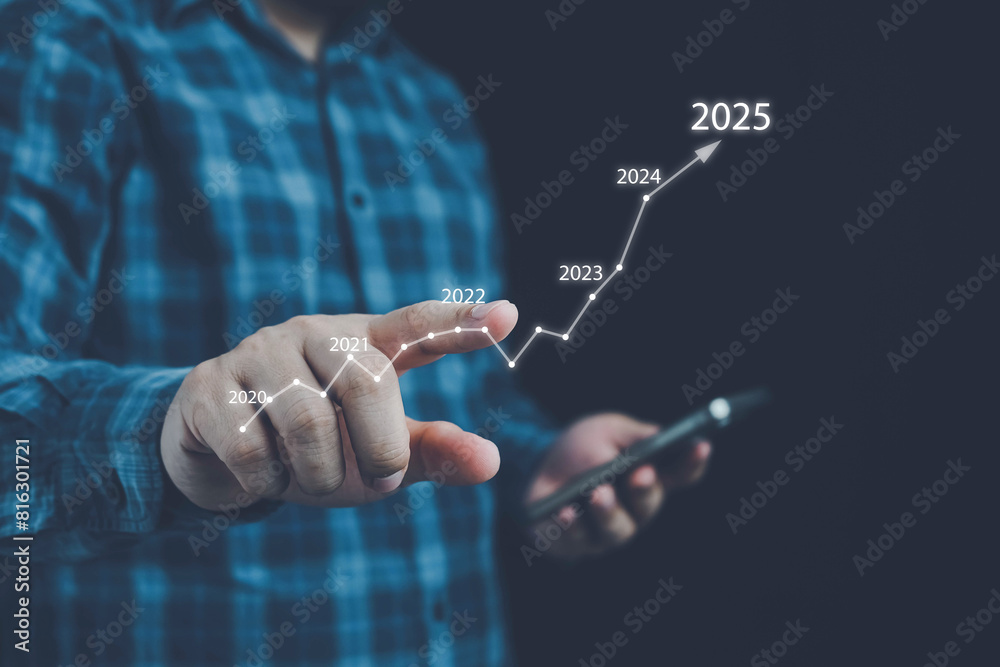 Fototapeta premium 2025 business growth, Businessman holding growth graph a year 2025 of business and data analysis. 2024 to 2025, Development to success in year 2025. challenge and business strategy in new year.