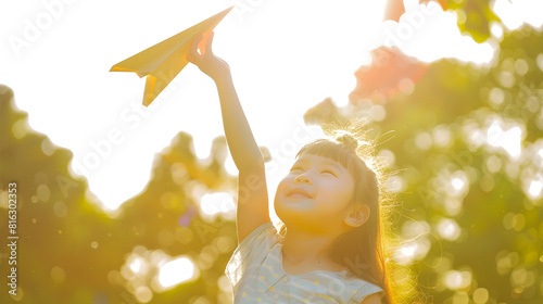Cute girl throwing paper airplane at summer park Happy childhood travel vacation concept : Generative AI