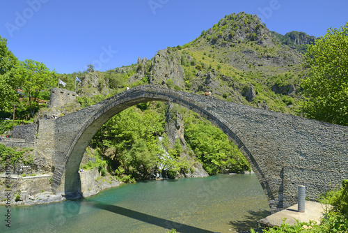 The historical stone arced bridge of Konitsa in Epirus - view of the old stoned bridge of Konitsa over the beautiful Aoos river, Zagori, Greece