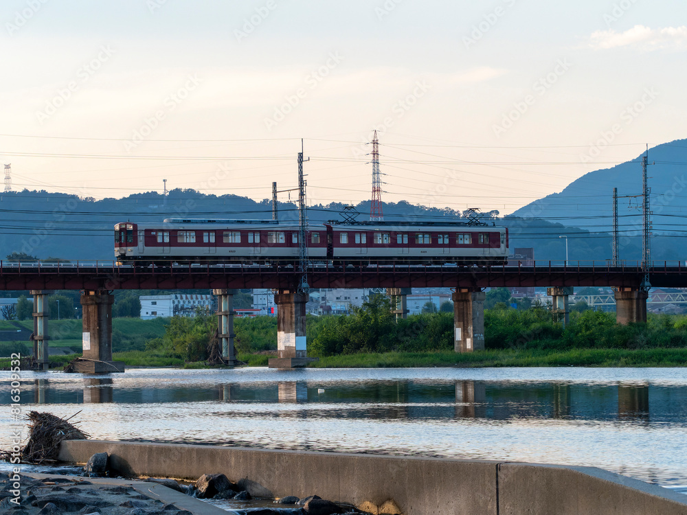 Fototapeta premium 早朝の大和川を渡る近鉄道明寺線の電車
