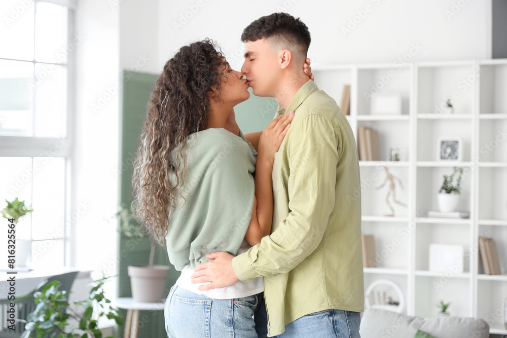 Happy young beautiful couple kissing at home Happy young beautiful couple kissing at home