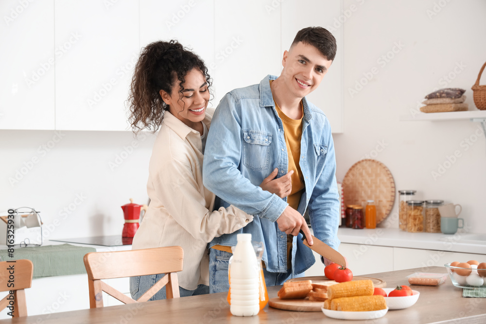 Happy young couple cooking together at home