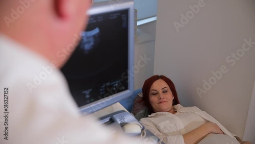 Middle-aged woman during ultrasound diagnosis in the office, lying on the couch.  photo