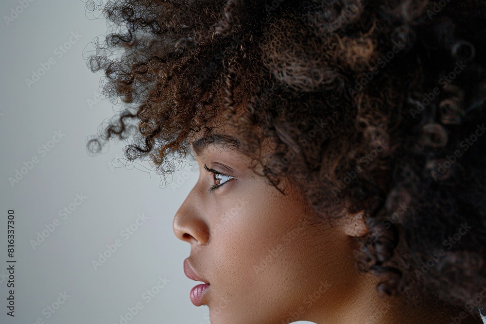 Contemplative Portrait: A Woman with Curly Hair and a Serene Expression