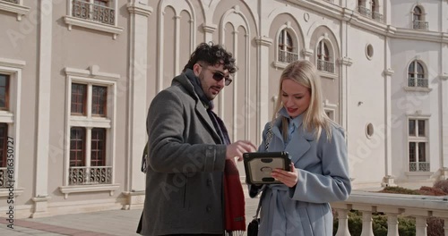 Wallpaper Mural Business partners discussing data analysis, project issues or strategizing using a tablet while working remotely out in the city, on a sunny day. Torontodigital.ca