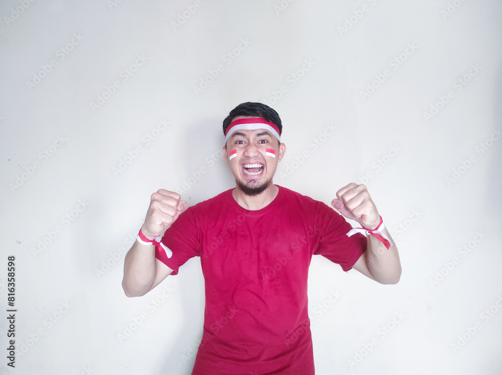 Naklejka premium Indonesian man clenches fist with excited and happy expression on independence day