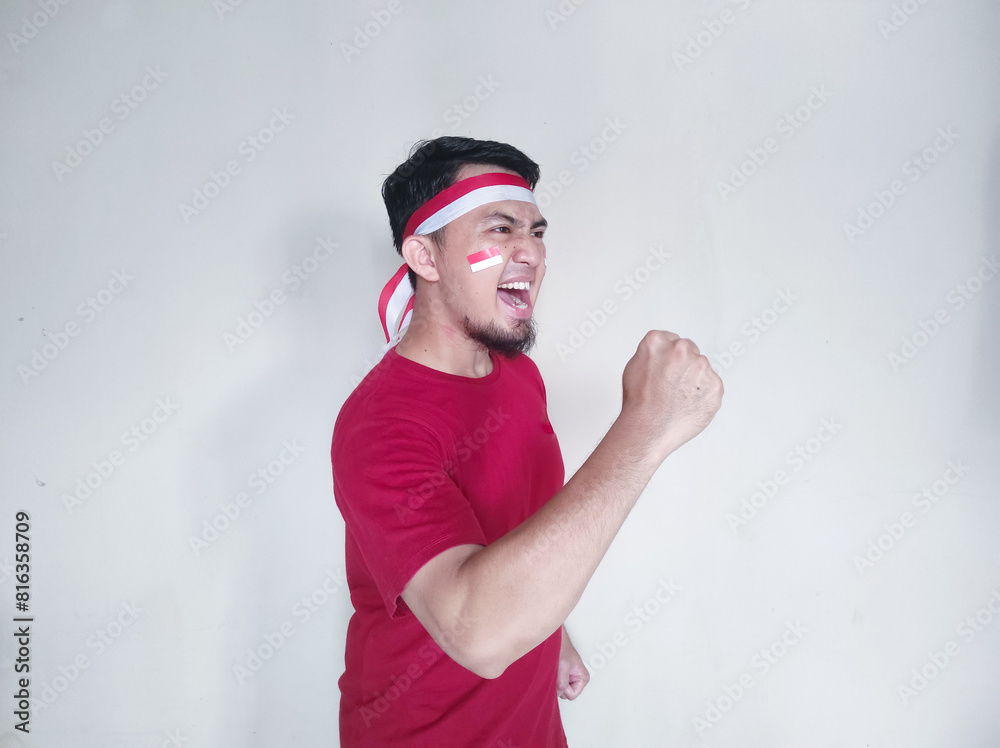 Naklejka premium Indonesian man clenches fist with excited and happy expression on independence day
