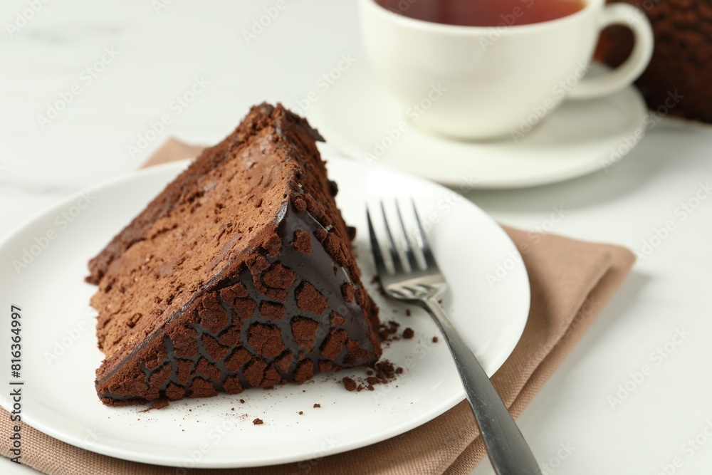 Piece of delicious chocolate truffle cake and fork on white table, closeup Piece of delicious chocolate truffle cake and fork on white table, closeup