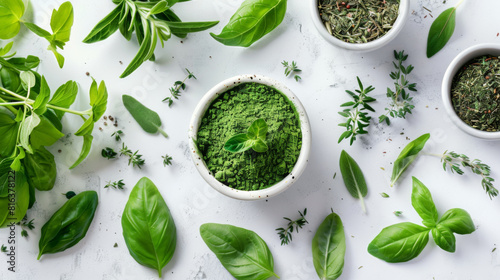 Assortment of fresh herbs and vibrant green herbal powder displayed on a clean white surface.