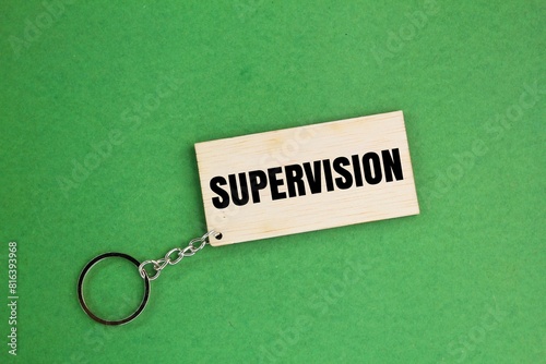 wooden tag with the word supervision. the concept of surveillance