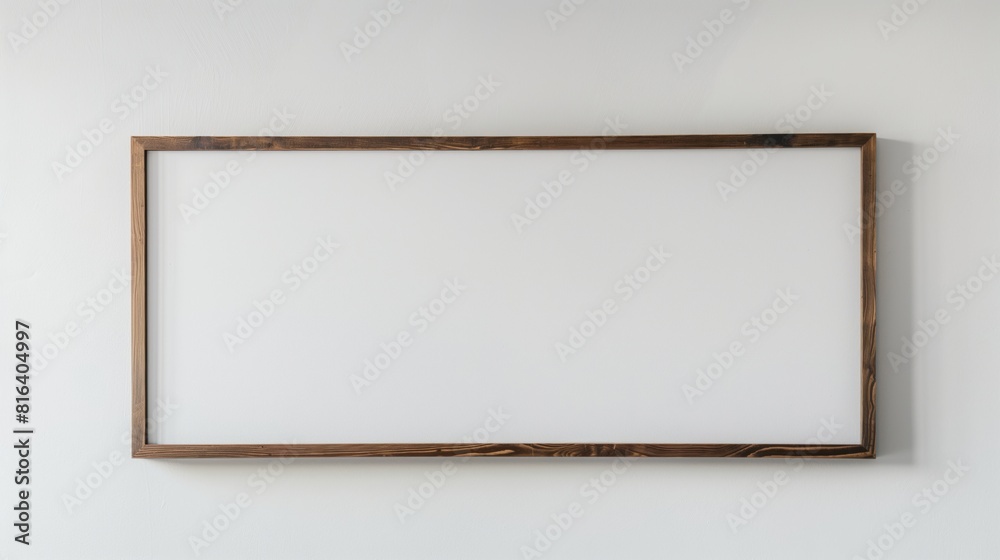 Simple wooden frame hanging on a plain white wall during the day. Simple wooden frame hanging on a plain white wall during the day.