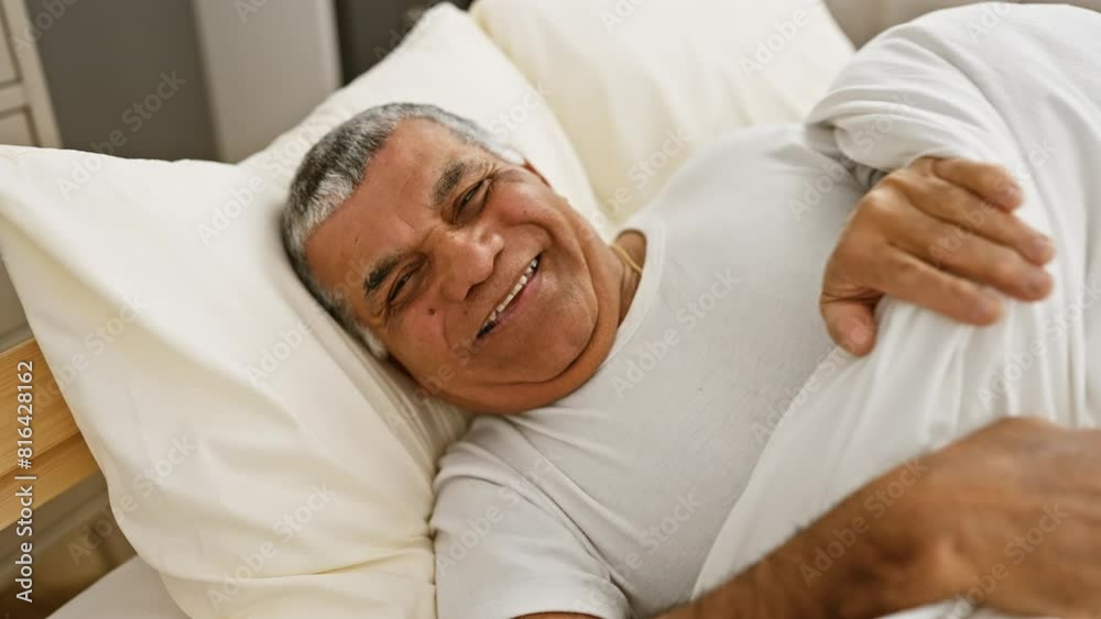 Smiling senior man lying comfortably in a bedroom, expressing relaxation and contentment in a home setting. Smiling senior man lying comfortably in a bedroom, expressing relaxation and contentment in a home setting.