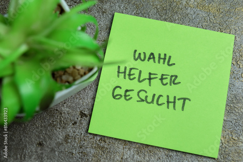 Concept of Learning language - German. Wahl Helfer Gesucht it means Election helper wanted written on sticky notes. German language isolated on Wooden Table.