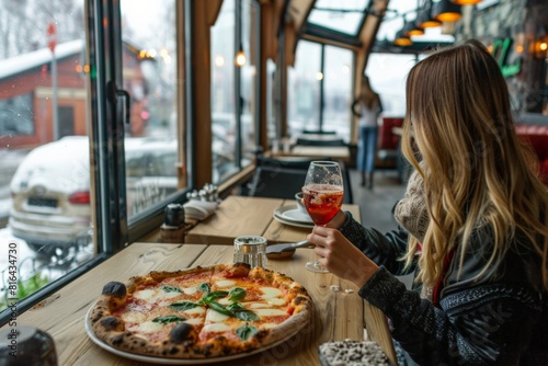 Woman enjoying pizza and wine at table, fast food feast