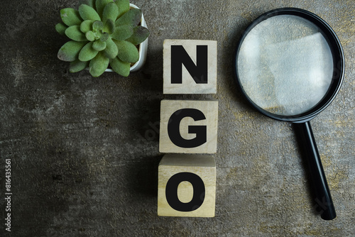 Concept of The wooden Cubes with the word NGO - Non-Governmental Organization on wooden background. photo