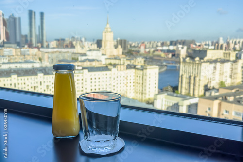 Canvas Print Empty glass and bottle of natural juice on the windowsill