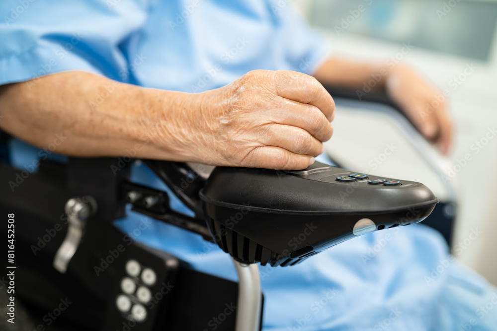 Asian senior woman patient on electric wheelchair with remote control at hospital, healthy strong medical concept. Asian senior woman patient on electric wheelchair with remote control at hospital, healthy strong medical concept.
