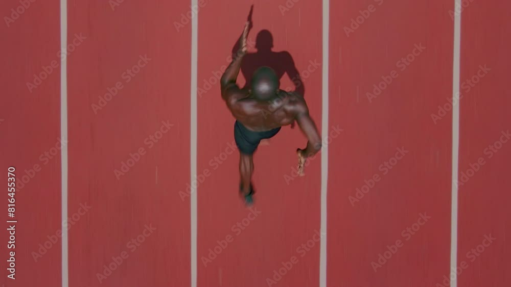 Top view of an African ethnicity athlete man running on the stadium followed by a drone