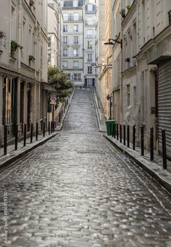 Obraz na płótnie Perspective view of one of the old montmartre streets in Paris. A narrow cobblestone street with typical French architecture descends and rises, The historic district of Montmartre in the city of Pari w salonie