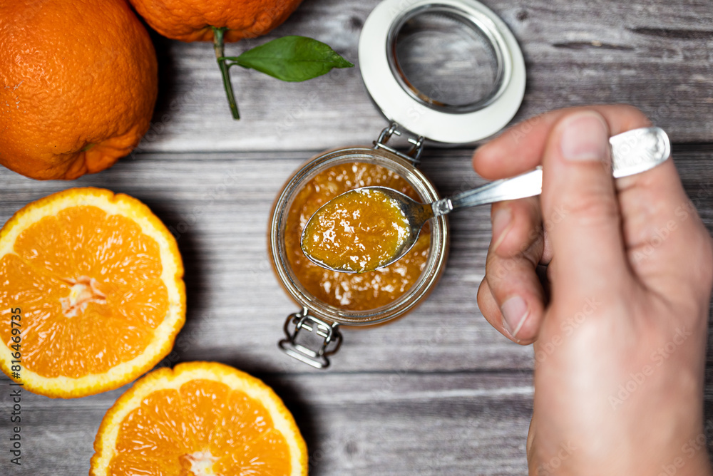 Man holding a teaspoon with orange jam. Delicious homemade orange jam, healthy breakfast. Man holding a teaspoon with orange jam. Delicious homemade orange jam, healthy breakfast.