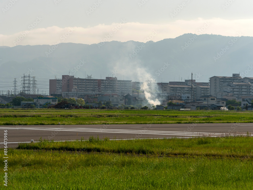 Fototapeta premium 八尾空港と畑の野焼きの風景
