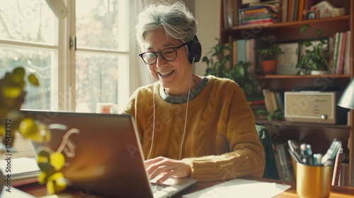 A smiling senior woman with short gray hair and glasses, wearing over-ear headphones and a casual outfit, 