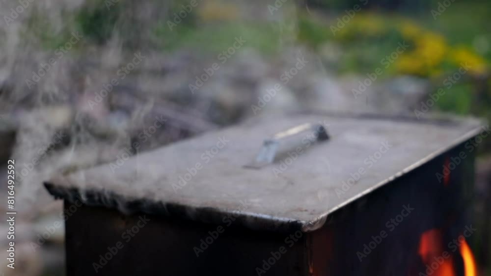 there is a metal smokehouse in the garden, where fish is smoked