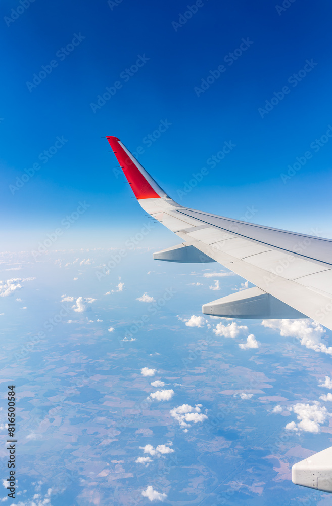 View from the airplane window at a beautiful cloudy sky and the airplane wing View from the airplane window at a beautiful cloudy sky and the airplane wing