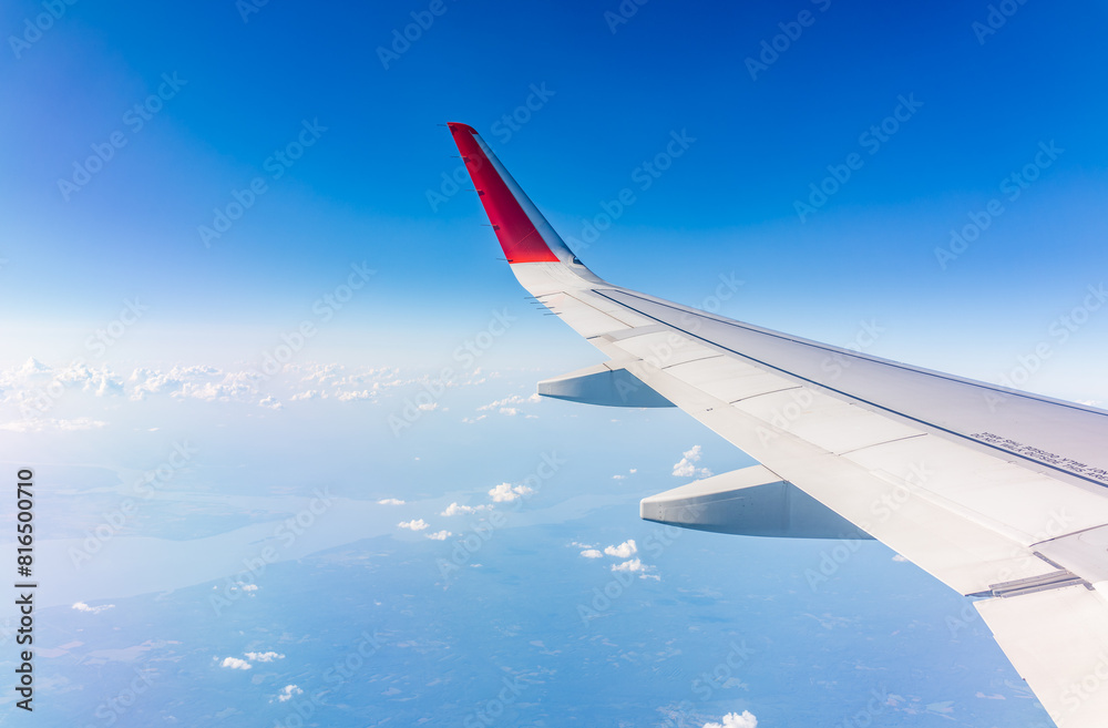 View from the airplane window at a beautiful cloudy sky and the airplane wing