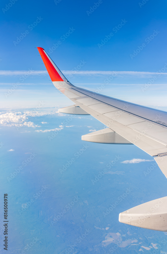 View from the airplane window at a beautiful cloudy sky and the airplane wing View from the airplane window at a beautiful cloudy sky and the airplane wing