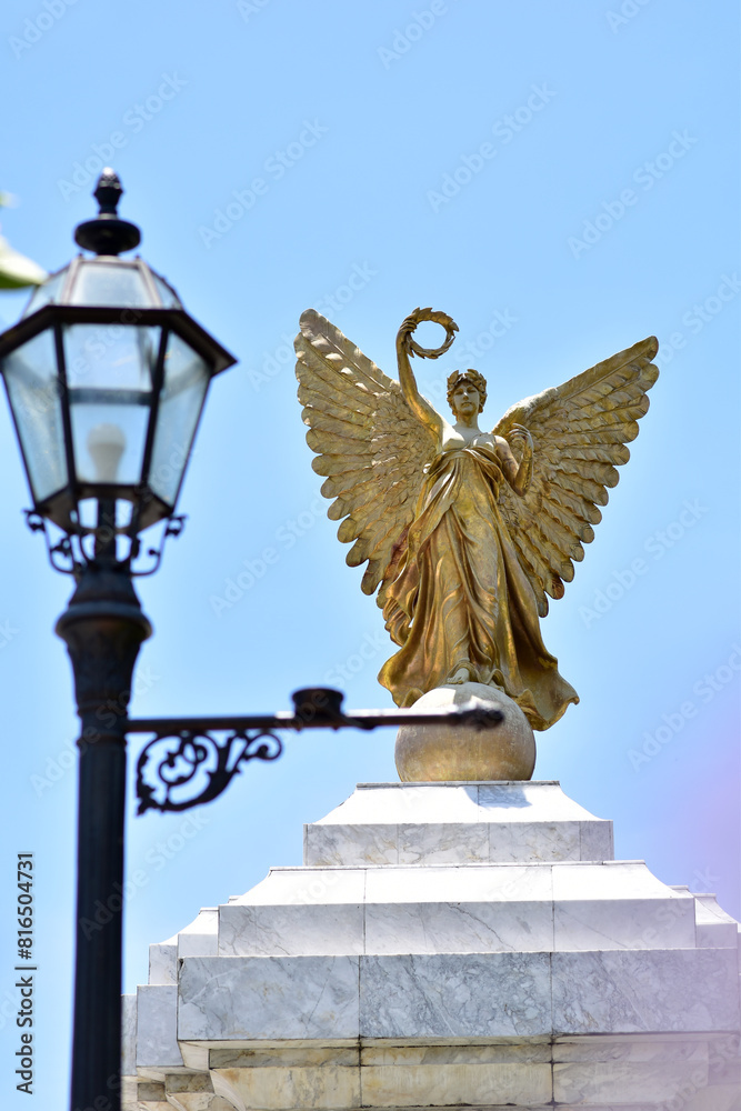 Obraz premium SAMUTPRAKAN, THAILAND - May 16, 2024: Statue of The Golden Angel Independence Monument at Assumption University, Suvarnabhumi Campus, Thailand.