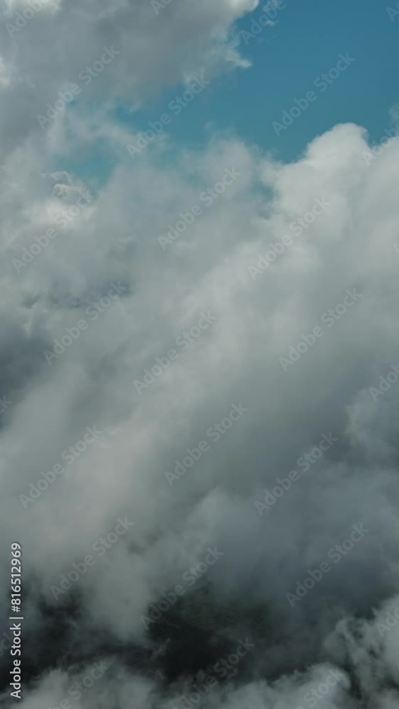 Flying through beautiful white fluffy clouds in blue sky. Airplane travel background. Vertical video Flying through beautiful white fluffy clouds in blue sky. Airplane travel background. Vertical video