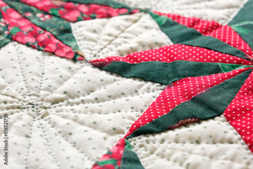 Closeup patchwork or quilt with christmas star motifs in green, red and white.	