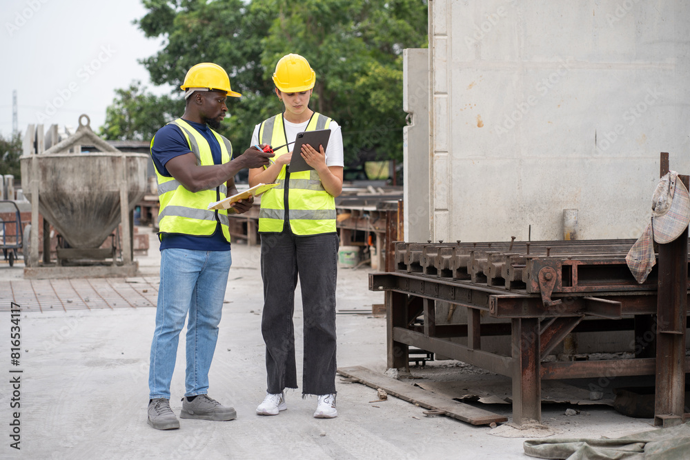 Portrait African engineer man use clipboard and Hispanic latin engineer woman use tablet computer checking precast cement at precast cement outdoor factory Portrait African engineer man use clipboard and Hispanic latin engineer woman use tablet computer checking precast cement at precast cement outdoor factory