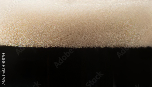Closeup of stout beer with bubbles and foam in glass