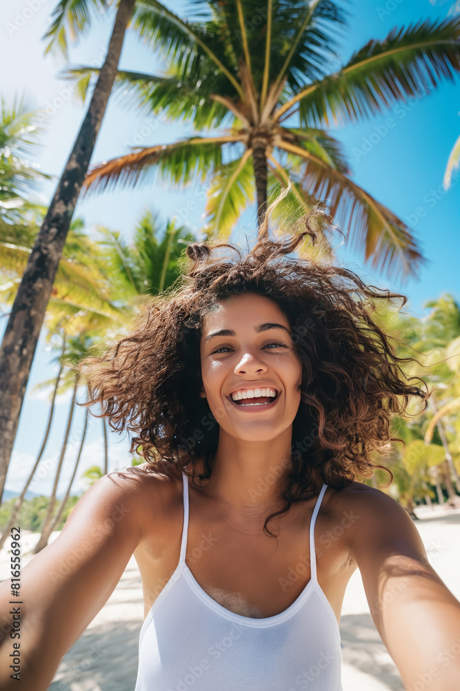 Smiling happy ethnic woman taking selfie photography at tropical beach with white sand and palm beach. Summer vacation in exotic resort, travel photo in a tropical paradise. Smiling happy ethnic woman taking selfie photography at tropical beach with white sand and palm beach. Summer vacation in exotic resort, travel photo in a tropical paradise.