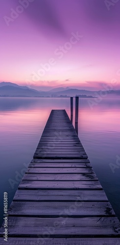 Lake with long wooden pier purple sky.