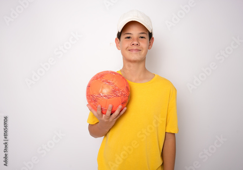 smiling teen boy in sportswear holding soccer ball showing isolated on white background