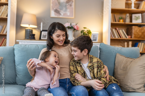In the familiar comfort of their living room, a mother, her daughter, and her son gather on the sofa , they create an scene of love and connection, sharing laughter and stories of their family life.